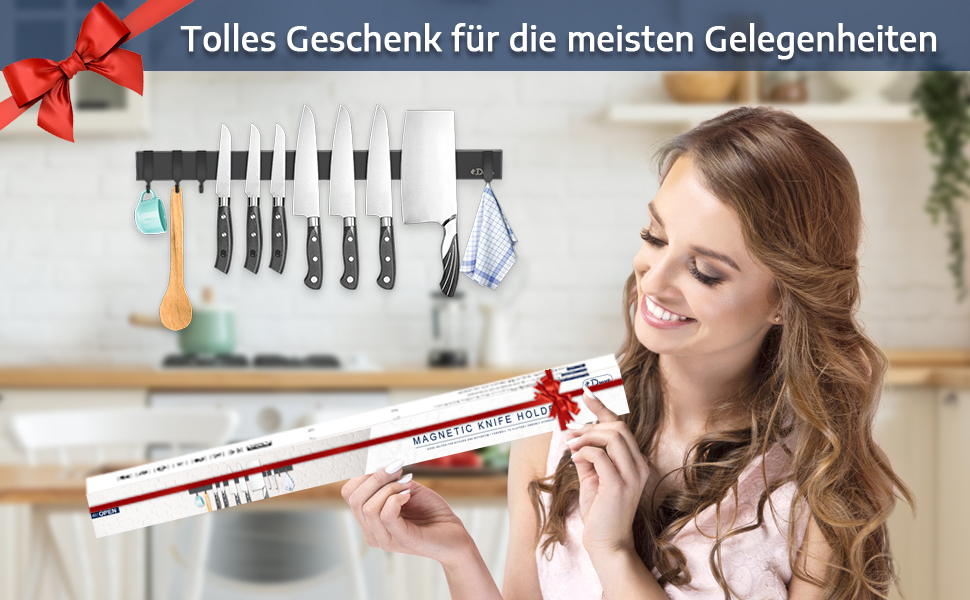 Porte-couteaux ou bande magnétique monté sur le mur de la cuisine avec différents couteaux. Texte allemand visible ci-dessus indiquant un article cadeau.