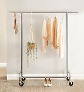 Le porte-vêtements est en métal et est muni d'une étagère.