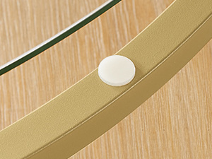 Petit capteur ou appareil circulaire blanc monté sur une surface en bois avec un panneau de verre au-dessus.