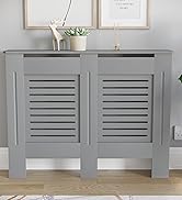 Cache radiateur gris avec panneaux frontaux à lattes, positionné contre un mur blanc sous une œuvre d'art encadrée