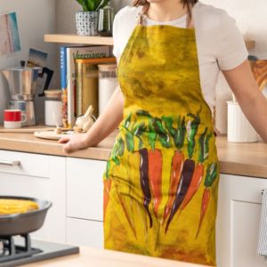 Jeune femme dans sa cuisine avec un tablier coloré