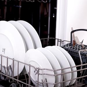 Intérieur d'un lave-vaisselle avec des assiettes blanches et de la vaisselle soigneusement rangées dans les paniers, démontrant une technique de chargement appropriée