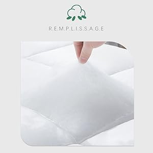 Gros plan d'un tissu blanc ou d'un matériau de rembourrage manipulé à la main, présentant une texture douce et une construction en peluche. Logo de la marque « Remplissage » visible ci-dessus.