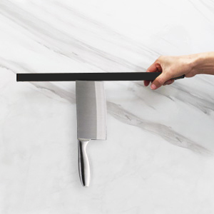 une main tenant un couteau sur un comptoir de cuisine