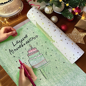 Carnet ouvert ou agenda avec couverture vert menthe avec illustration et écriture de gâteaux, photographié avec des décorations de Noël à proximité.
