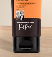 Contenant de produits capillaires orange et noir avec la marque emblématique affichée sur une surface en bois.