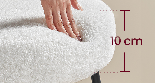 En appuyant à la main sur une surface en tissu épais et blanc en peluche. Un indicateur de mesure indique que la profondeur du tissu est de 10 cm. Le matériau semble doux et moelleux.