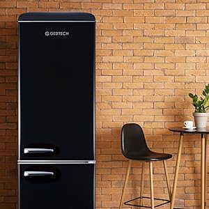 un réfrigérateur et des tabourets noirs devant un mur de briques