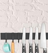 avec quatre lames en acier inoxydable de différentes tailles, affichées sur une bande magnétique noire avec des ustensiles colorés suspendus en dessous.