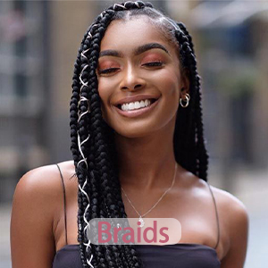 Un gros plan d'une longue coiffure tressée foncée aux reflets blonds. La superposition de texte indique « Braids »