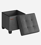 en tissu gris avec couvercle capitonné amovible. Forme carrée avec jambes courtes. Compartiment de rangement intérieur visible. Petite étiquette rouge sur le côté.