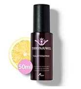 Flacon en verre foncé contenant un produit de soin de la peau affiché à côté d'une tranche de citron frais sur fond blanc.