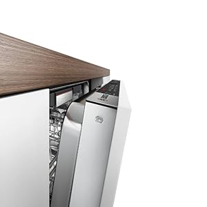 Gros plan d'une installation d'appareils encastrés ou intégrés, montrant un plan de travail ou une surface en bois rencontrant des panneaux d'appareils blancs.