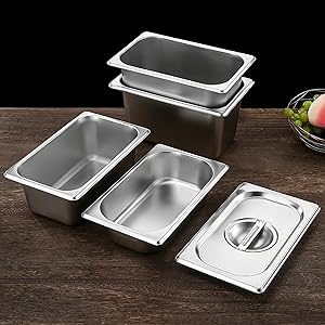 Contenants pour services alimentaires en acier inoxydable de différentes tailles exposés sur une surface en bois. Comprend des casseroles profondes et peu profondes avec un couvercle visible.