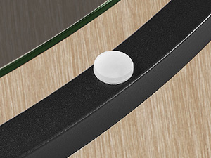 Détail rapproché d'un élément de commande ou de bouton circulaire blanc positionné sur une surface noire et boisée