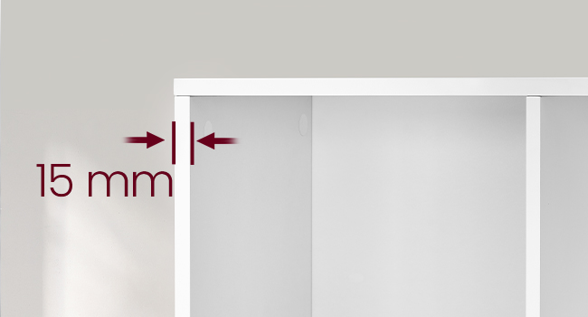 Gros plan d'un bord ou d'un panneau de meuble blanc avec une flèche rouge indiquant une mesure ou un écart de 15 mm