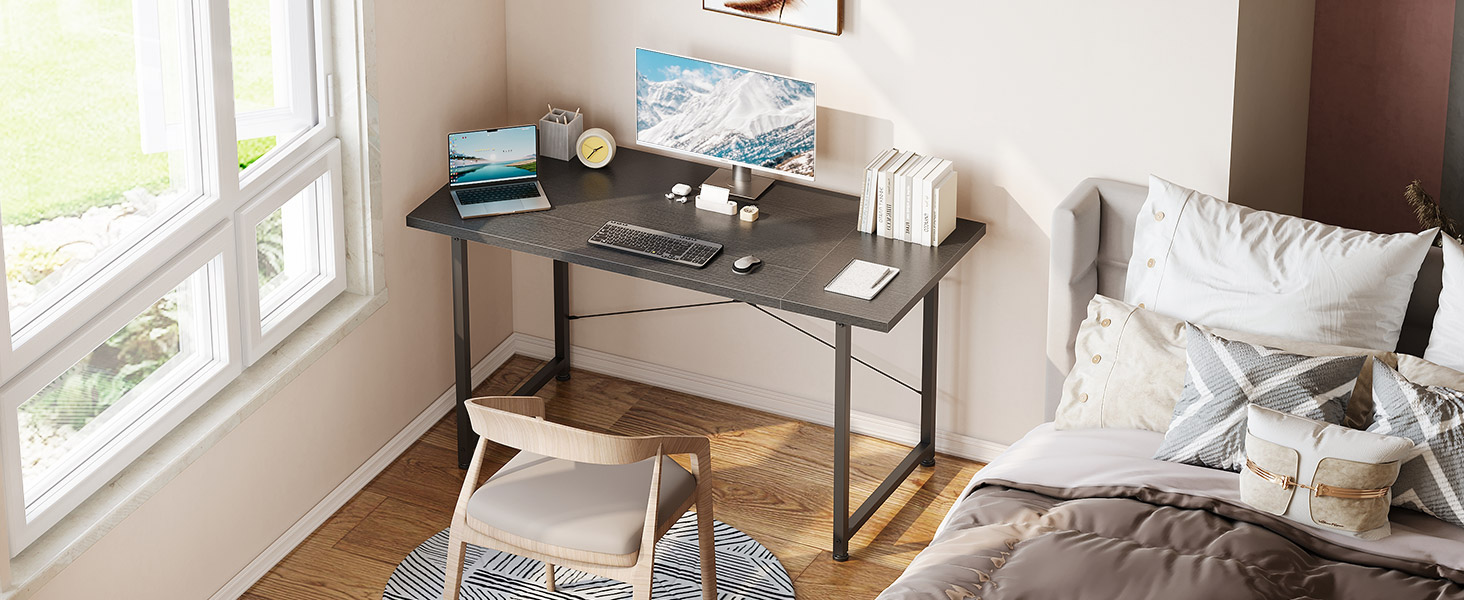 Intérieur de salon moderne avec canapé gris, table basse à ossature métallique et grandes fenêtres laissant entrer la lumière naturelle.
