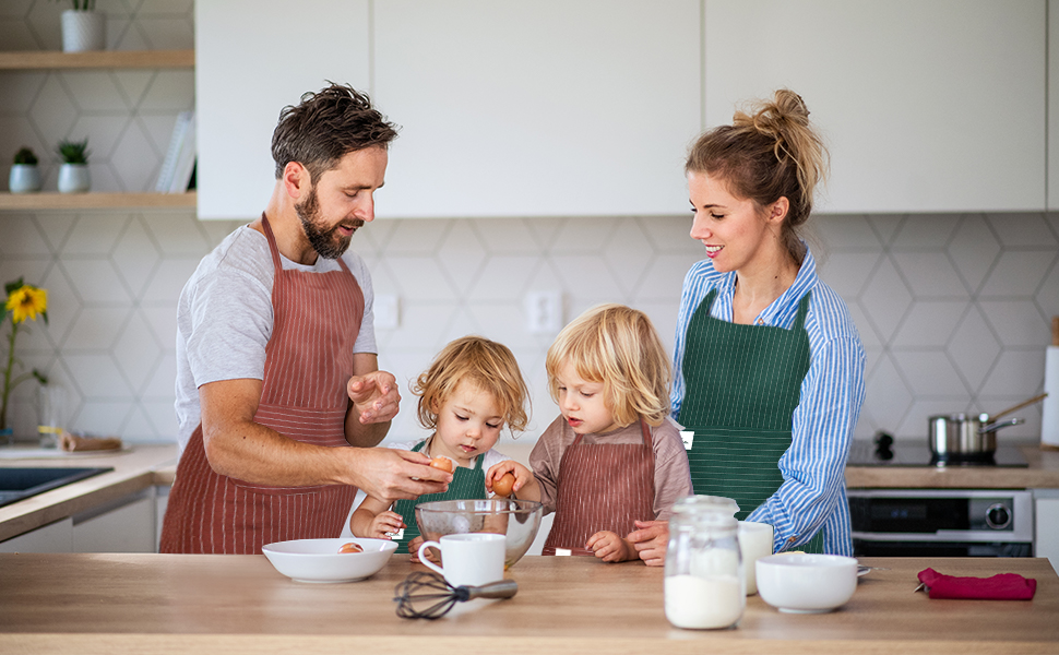 Scène de cuisine avec des tabliers assortis et des ingrédients de cuisson sur le comptoir, y compris des bols et des contenants contenant ce qui semble être de la farine ou du lait