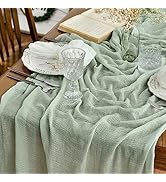 Nappe ou tissu vert menthe drapé sur un décor de table à manger, présentant une texture de tissu fluide.
