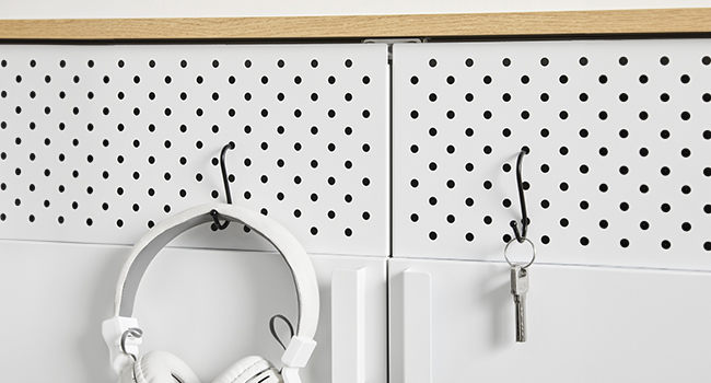 un panneau perforé blanc sur lequel est accrochée une paire de clés