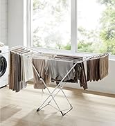 Séchoir pliable près d'une fenêtre, pouvant contenir plusieurs vêtements. Structure en métal avec bras étendus pour suspendre les vêtements, adaptée à une utilisation en intérieur.