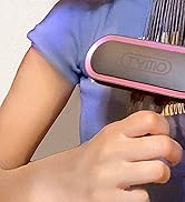 Brosse à cheveux à bordure rose avec poils foncés utilisée pour coiffer les cheveux, montrant un gros plan