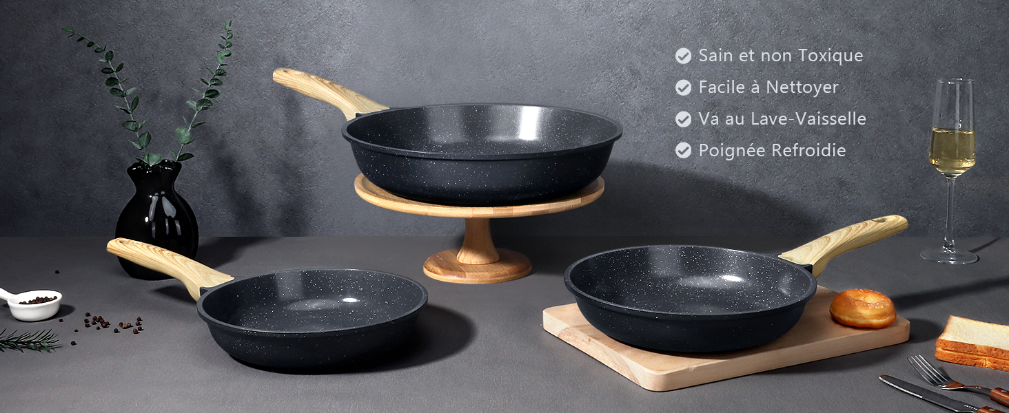 Ensemble de trois poêles antiadhésives noires avec poignées en bois. Casseroles affichées sur fond sombre avec accessoires de cuisine. Le texte indique des caractéristiques faciles à nettoyer et lavables au lave-vaisselle.