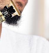 Gros plan d'une tondeuse à barbe en cours d'utilisation, montrant les composants noirs et dorés de l'appareil sur une barbe foncée