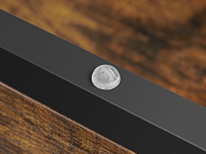 Gros plan du bord d'un appareil électronique noir avec un petit bouton ou un capteur circulaire argenté visible