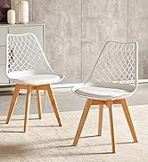 Deux chaises de salle à manger modernes dotées de sièges à motifs géométriques blancs, de pieds en bois et de sièges rembourrés contre un mur d'aspect béton