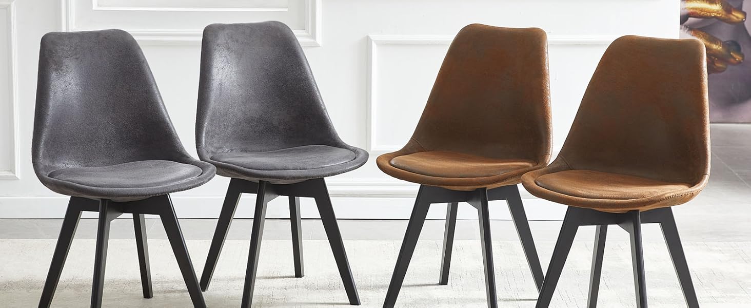 Ensemble de quatre chaises de salle à manger modernes avec revêtement gris et marron avec pieds en métal noir, disposées devant une grande fenêtre.