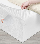 Gros plan d'un couvre-matelas ou d'un protège-matelas blanc en cours d'ajustement ou d'installation sur un coin d'un matelas