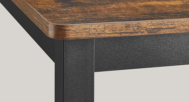 Gros plan d'un coin de table, montrant une surface supérieure en grain de bois avec un cadre en métal foncé en dessous