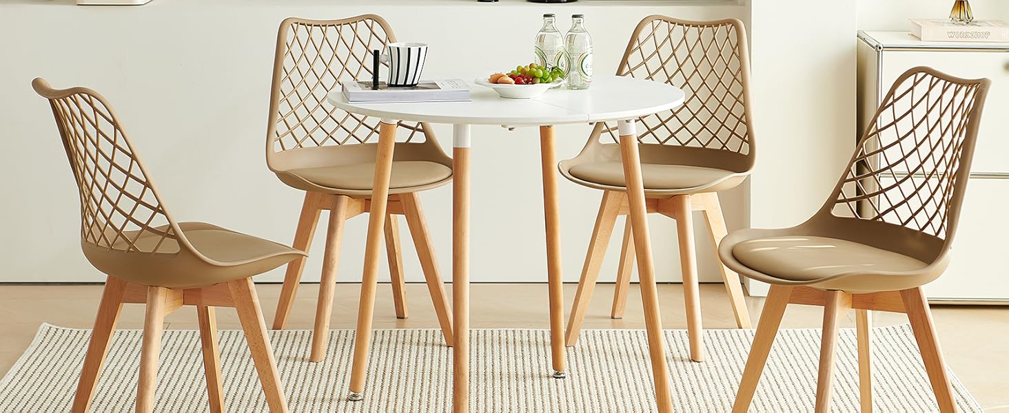 avec table ronde blanche et quatre chaises beiges avec dossiers à motifs en treillis. Situé sur un tapis de couleur claire dans une pièce minimaliste avec rangement mural en panneau perforé