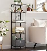 dans le salon. Expose des plantes, des livres et des objets de décoration. Positionné à côté d'un fauteuil blanc.