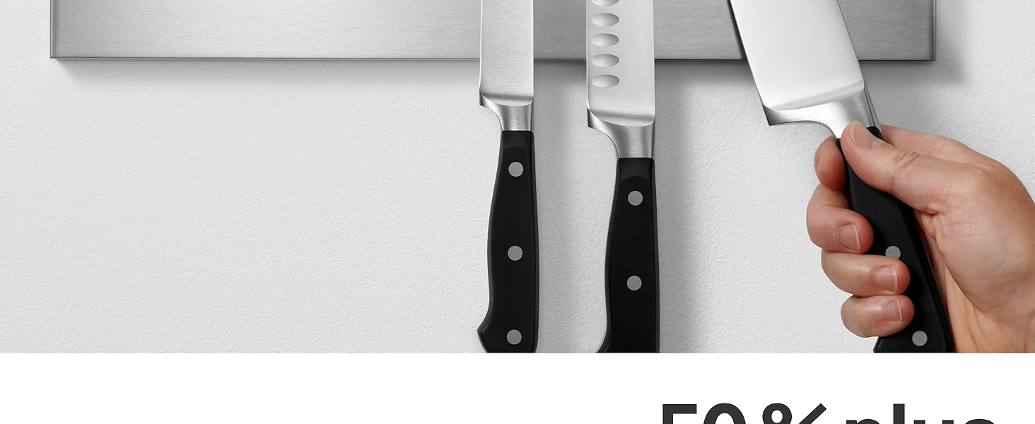 Trois couteaux de cuisine au manche noir montés sur une bande magnétique. Une main tend la main pour saisir l'un des couteaux.