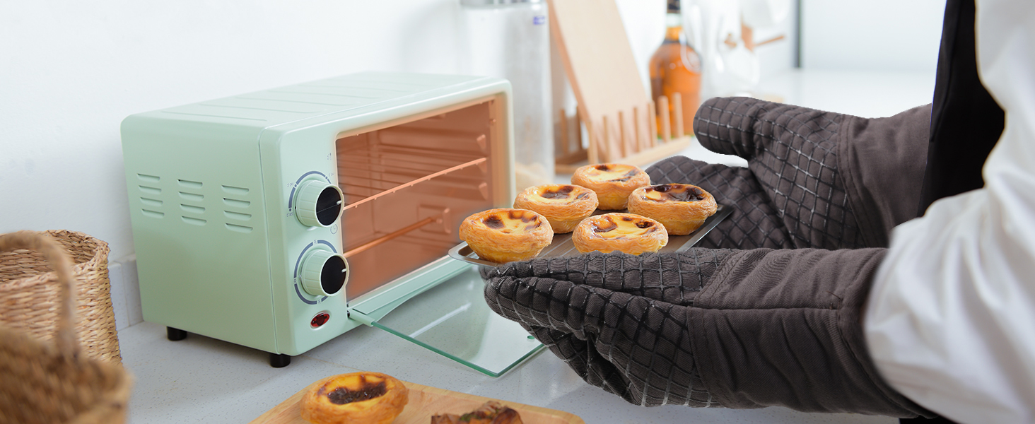 avec pâtisseries cuites à l'intérieur. Des mains portant des gants de cuisine sortent du four un plateau de produits fraîchement sortis du four