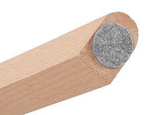 Gros plan d'une butée de porte en bois ou d'un pied de meuble. Design effilé avec un tampon circulaire en feutre gris fixé à une extrémité pour protéger le sol