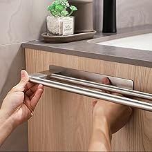 une personne tient une poignée de tiroir de salle de bain.