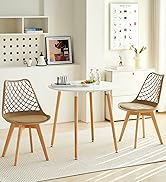 avec table ronde blanche et deux chaises brunes à dossier en treillis. Pieds en bois sur les meubles. Étagères murales décoratives et œuvres d'art visibles en arrière-plan.