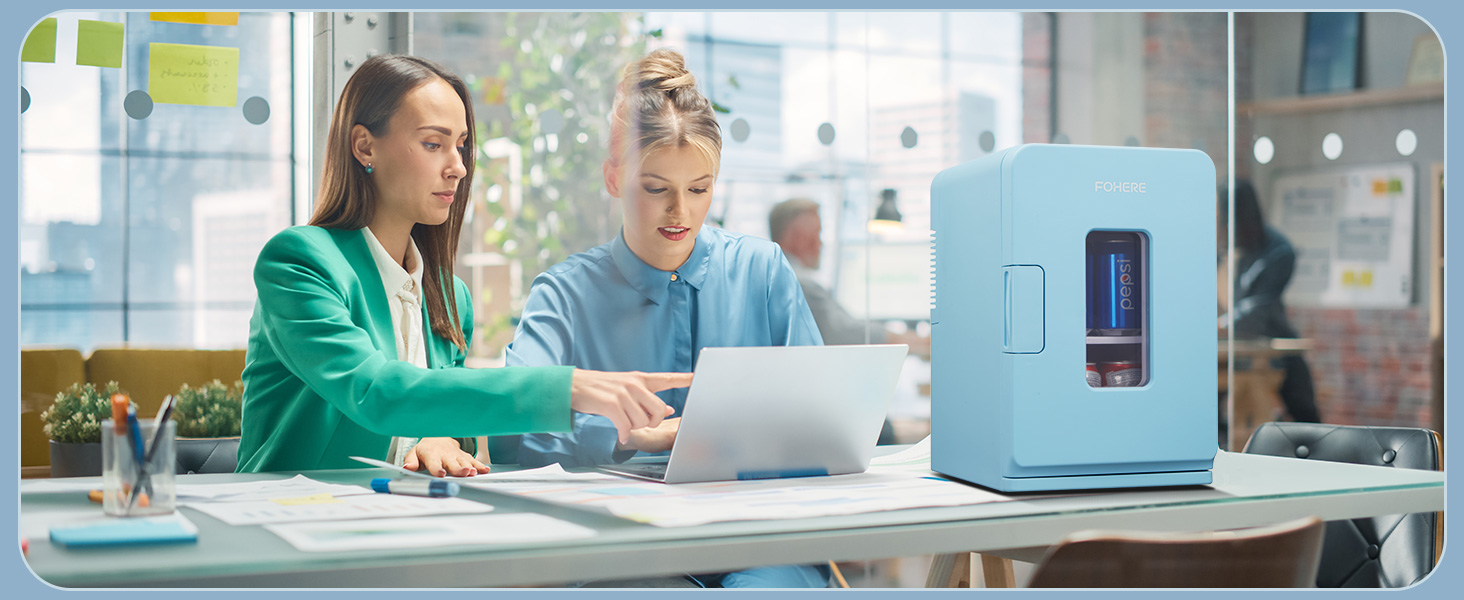 Cadre de bureau avec deux personnes travaillant au bureau à côté d'un appareil ou d'un appareil compact bleu clair.