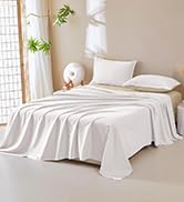 posée sur un lit, présentant une texture nette et unie avec un style minimal sur des murs de couleur claire