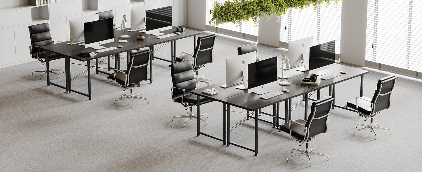 Espace de bureau moderne avec plusieurs postes de travail comprenant des bureaux et des chaises noirs disposés en rangées, avec de grandes fenêtres laissant entrer la lumière naturelle.