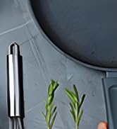 un gros plan d'un plateau en métal avec un brin de romarin dessus