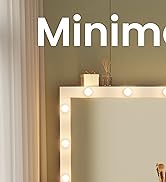 Coin d'un miroir de courtoisie avec ampoules lumineuses autour du cadre. Le miroir reflète un mur vert et un rideau blanc. Objets décoratifs visibles sur le dessus.