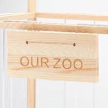 Le texte se lit comme suit : « NOTRE ZOO » est gravé ou gravé sur un panneau ou une plaque en bois naturel.