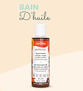 Flacon en verre contenant un produit huileux teinté d'orange avec le texte « Bain d'Huile »