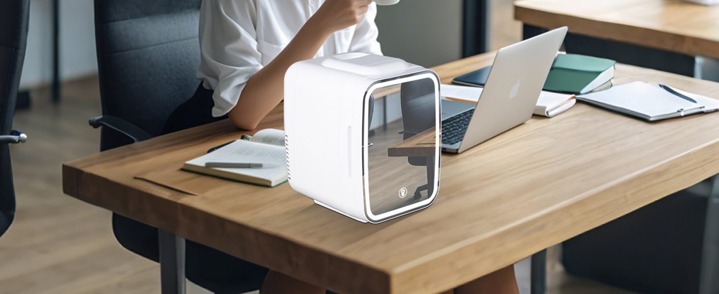Appareil blanc en forme de cube sur un bureau en bois à côté d'un ordinateur portable. Les mains de la personne sont visibles, ce qui suggère un bureau ou un environnement de travail.