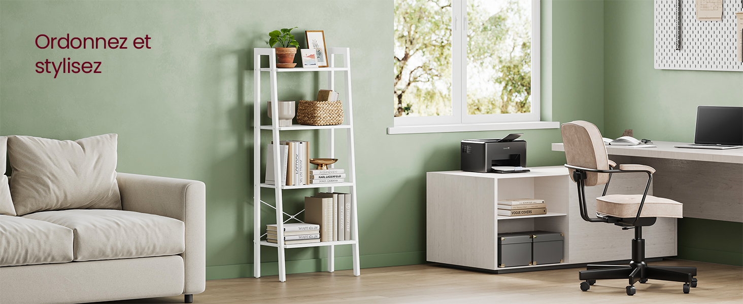Configuration de bureau à domicile moderne avec canapé gris, étagère blanche à plusieurs niveaux et agencement de bureau contre des murs vert sauge avec éclairage naturel