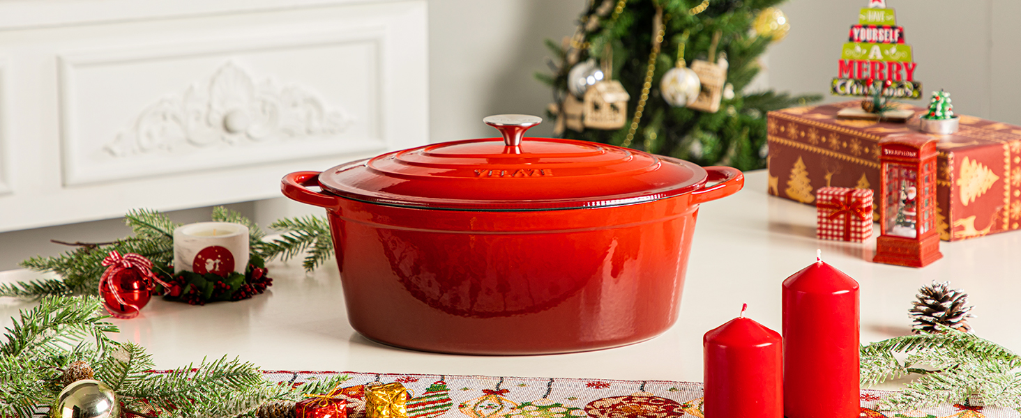 Grand four hollandais en fonte émaillée rouge sur le comptoir de la cuisine avec décorations de Noël, mettant en valeur sa forme ronde et son couvercle avec poignée